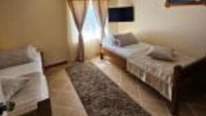 A room with two beds, a TV, and a window with curtains. - Villa Radalj (Makarska)