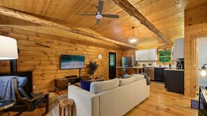 A cozy log cabin interior with a living room, kitchen, and dining area. - Modern Cabin w/ Trail to Waterfall/Cave/Cliff (FV) (Rockbridge)