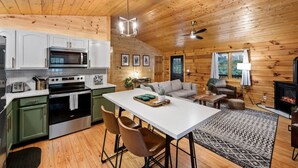 A cozy cabin interior with a kitchen, dining area, and living room. - Modern Cabin w/ Trail to Waterfall/Cave/Cliff (TF) (Rockbridge)