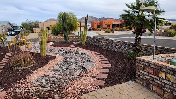 Un giardino curato con cactus e un vialetto lastricato.