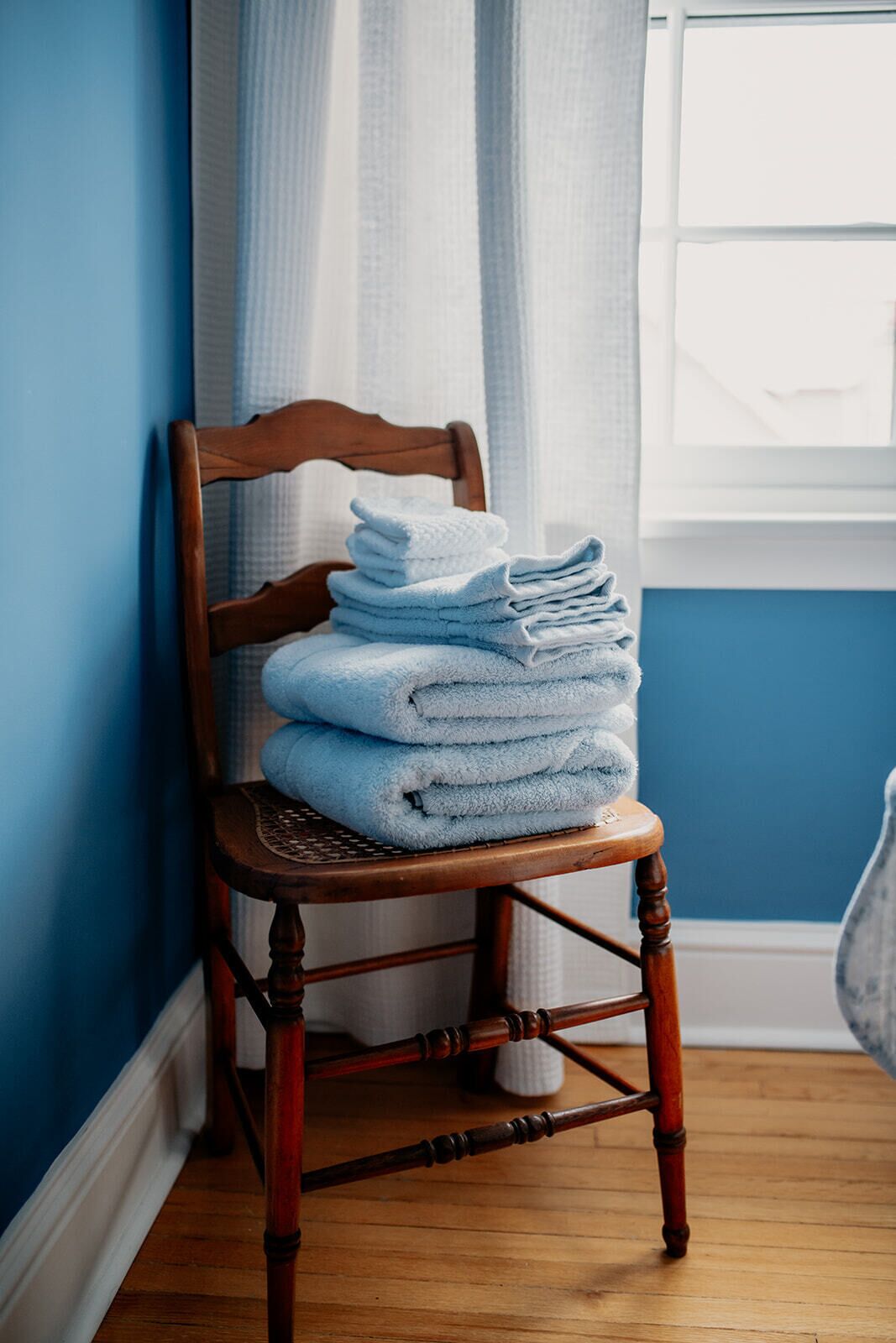 Une chaise en bois avec une pile de serviettes pliées.