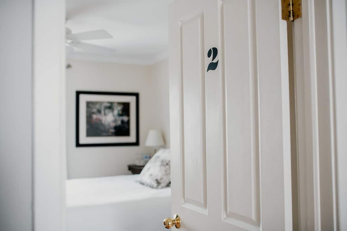 A white door with a brass doorknob and a number '2' sticker.