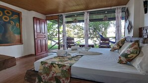 Un dormitorio con una cama, un cuadro y vistas al exterior.