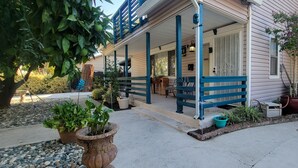A two-story house with a porch, potted plants, and a small garden area. - Spacious Luxury Comforters of home while enjoying time away w/community pool :) (Roseville)