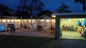 An outdoor patio area with a grill, chairs, and a bike rack.