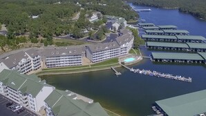 Luchtbeeld van een hotel aan het water, met meerdere boten afgemeerd, een zwembad en een parkeerplaats.