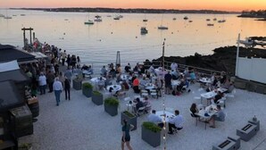 A waterfront restaurant with outdoor seating overlooking the sea, boats, and a sunset. - Amazing harbor/ocean views of Pepperrell Cove (Kittery)