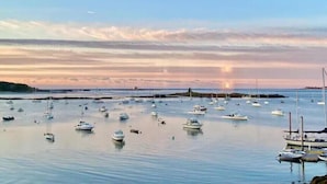 A marina with multiple boats docked at calm waters during sunset. - Amazing harbor/ocean views of Pepperrell Cove (Kittery)