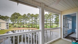 A covered outdoor area with a view of a lake and trees, a white railing, and a door leading to an interior space. - 8 Mi to Boardwalk: Myrtle Beach Condo Near Golfing (Myrtle Beach)