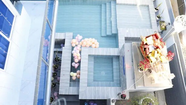 A rooftop pool area with a geometric design, surrounded by potted plants and a small seating area with cushions. - Rowena's River Resort with private pool  5minutes away from Our Lady of Manaoag  (Manaoag)