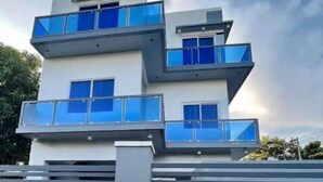 A modern multi-story building with balconies and large windows. - Rowena's River Resort with private pool  5minutes away from Our Lady of Manaoag  (Manaoag)