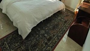 Une chambre à coucher avec un lit, un ventilateur de plafond, un appareil de climatisation et une fenêtre avec des rideaux.