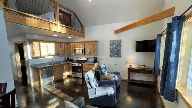 A spacious living area with a kitchen, a dining table, and a sofa. - Soldotna Kenai Moose Lane Cottages # 3  Central to Kenai and Soldotna. (Soldotna)