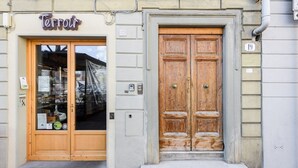 A building with a wooden double door and a shop entrance with a sign reading 'Terroir.' - Luxury San Niccolò in Florence by Mmega (Firenze)