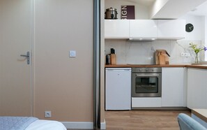 Eine kleine Küche mit Kühlschrank, Backofen und Holzarbeitsplatte.
