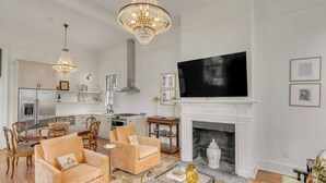 Un salon spacieux avec une cheminée, un téléviseur et un coin repas agrémenté de meubles en bois.