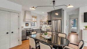 A modern kitchen with a central island, stainless steel appliances, and pendant lighting.