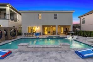 A modern two-story house with a swimming pool, outdoor seating, and a patio area. - Marvelous Muirfield | 10 BR, Ultra Themed Kids Rooms, Movie Theater (Kissimmee)