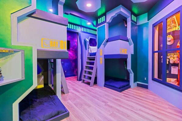 A children's play area with bunk beds, a slide, and a playhouse.