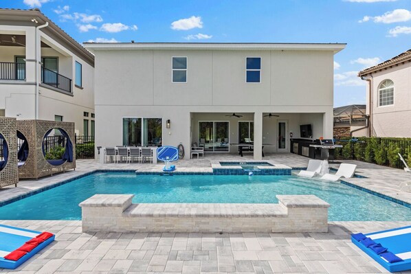 A modern two-story house with a swimming pool, outdoor seating, and a barbecue area. - Marvelous Muirfield | 10 BR, Ultra Themed Kids Rooms, Movie Theater (Kissimmee)