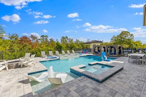 A swimming pool with lounge chairs and a small waterfall feature. - Marvelous Muirfield | 10 BR, Ultra Themed Kids Rooms, Movie Theater (Kissimmee)