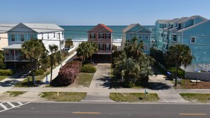 A beachfront residential area with houses, palm trees, and a clear view of the ocean. - Surfside Breezes - Second Row in Surfside Beach (Surfside Beach)