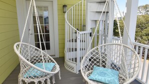 Two white macrame hanging chairs with blue cushions on a wooden deck. - Surfside Breezes - Second Row in Surfside Beach (Surfside Beach)