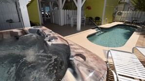 A hot tub and a small pool with lounge chairs and a covered patio area. - Surfside Breezes - Second Row in Surfside Beach (Surfside Beach)