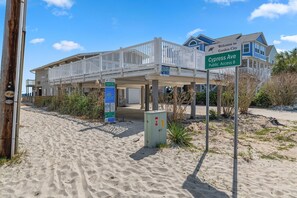 A beachfront property with a covered porch, a sign indicating Cypress Ave, and a beach access point. - Whispering Sands I 108 - Second Row in Garden City Beach (Garden City Beach)