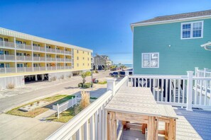 Un hôtel situé sur la côte, doté d’une terrasse en bois, d’un parking et offrant une vue sur la plage.