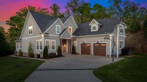 Ein zweistöckiges Haus mit Garage, Auffahrt und einem gepflegten Rasen.