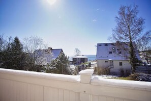 Ein Wohngebiet mit Häusern, blauem Himmel und Blick auf das Meer.