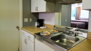 A compact kitchenette with a stainless steel sink, a coffee maker, and two plates on the counter. - Econo Lodge Mena near QueenWilhelmina State Park (Mena)