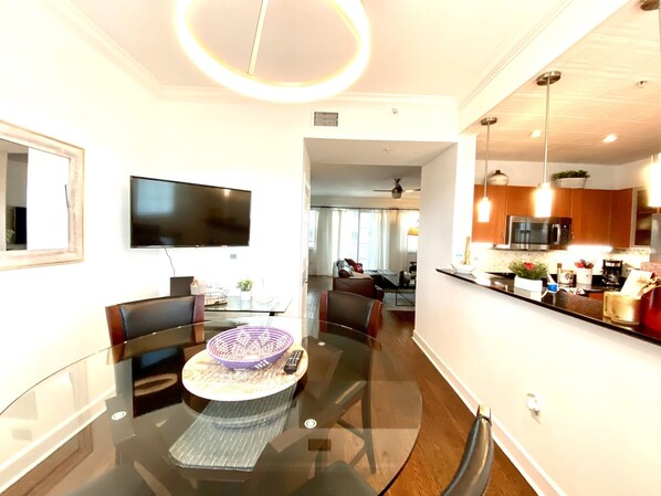 Relax in this spacious living area with a dining table, comfortable seating, and a flat-screen TV.
