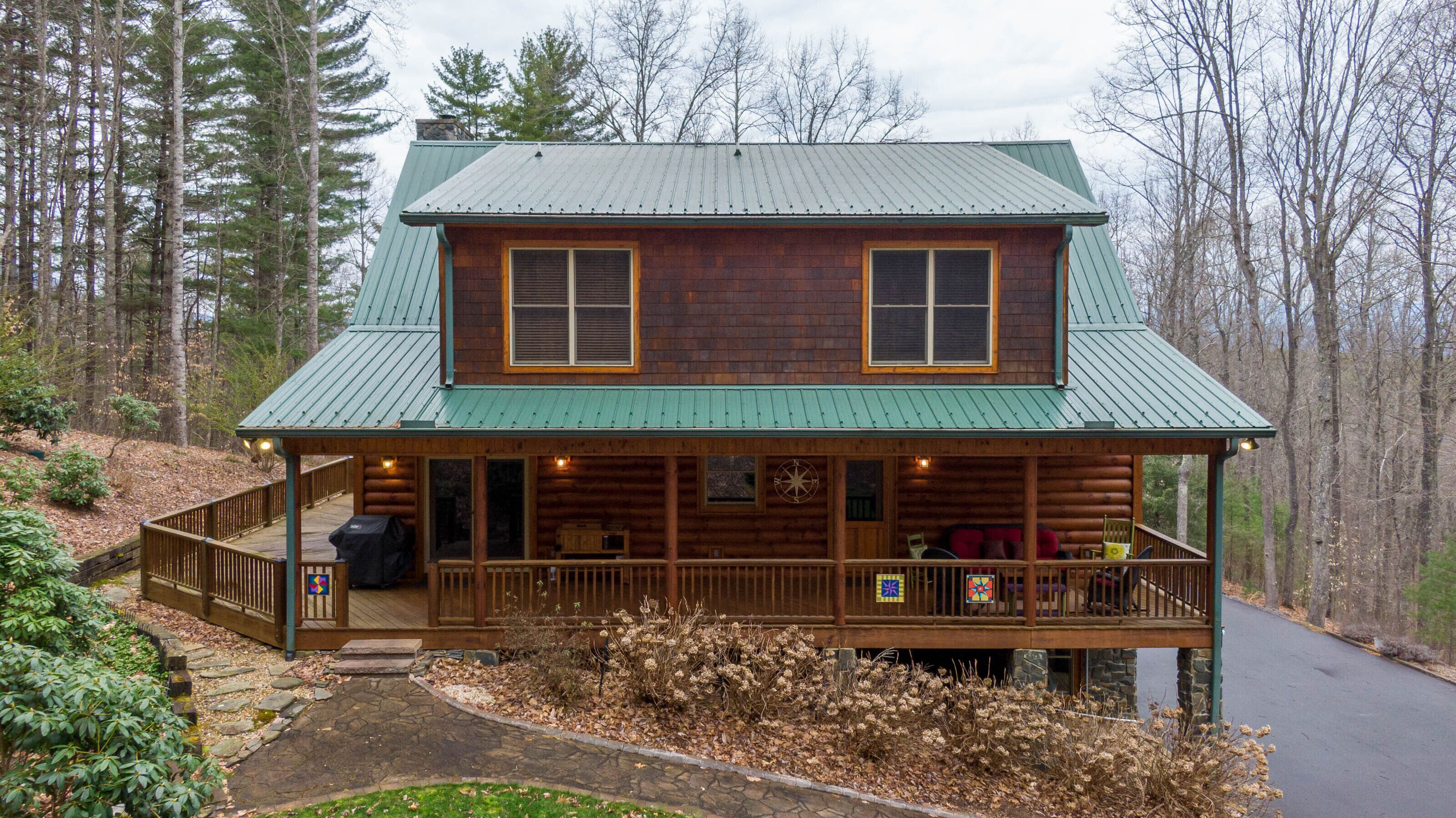 Classic log construction, a sweeping covered porch, and wooded seclusion waiting for your crew at The Forge in Blowing Rock.