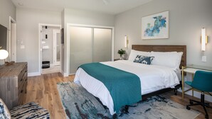 A bedroom with a bed, a desk, a chair, a ceiling fan, and a door leading to a bathroom. - 645 Fresh Modern Condo Inside Resort Gates - Free Wifi - Walk to Spa (Carlsbad)