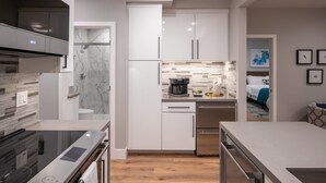 A modern kitchen with white cabinets, a built-in oven, and a coffee maker. - 645 Fresh Modern Condo Inside Resort Gates - Free Wifi - Walk to Spa (Carlsbad)