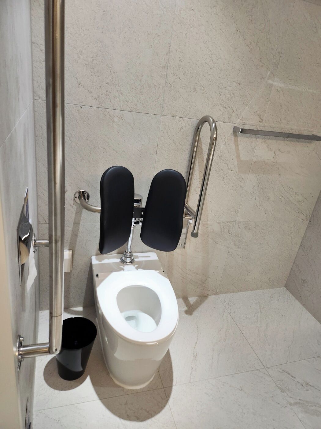 Ein modernes Badezimmer mit Toilette, Bidet und Haltestange.