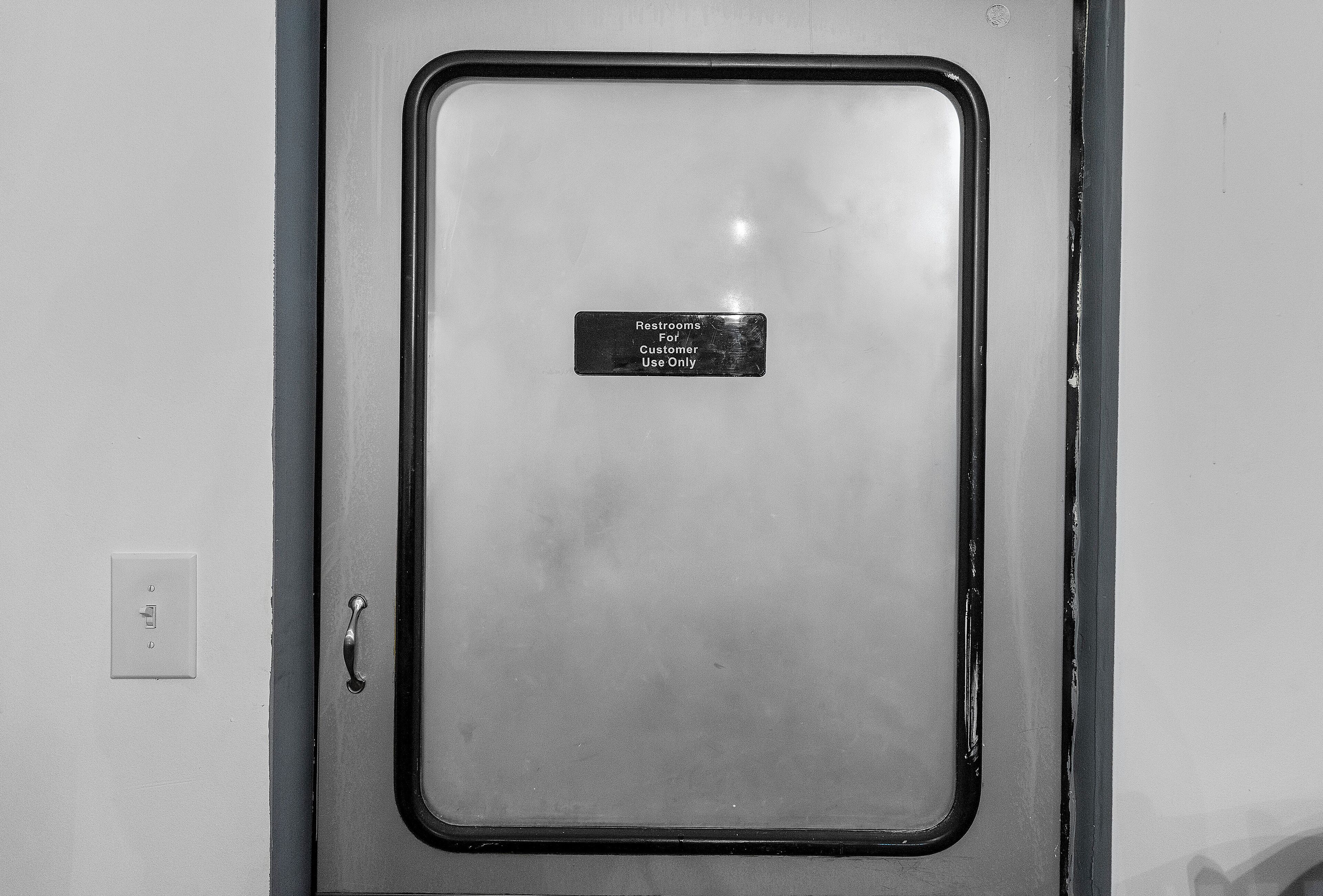 A restroom door with a sign indicating it is for customer use only.