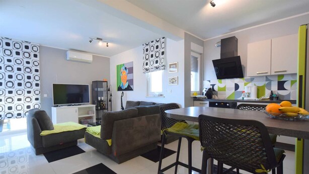 A modern kitchen with a dining area, a flat-screen TV, and a coffee machine. - Apartment Diva near the beach (Njivice)