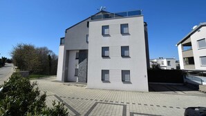 A modern multi-story residential building with a flat roof and large windows. - Apartment Diva near the beach (Njivice)