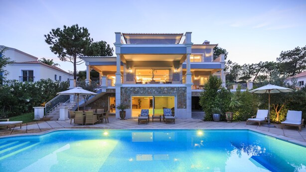 A two-story house with a swimming pool, outdoor seating, and a staircase leading to the upper level. - 5 Star Villa Cyclamen – Luxury Pools & Spa (Algarve)