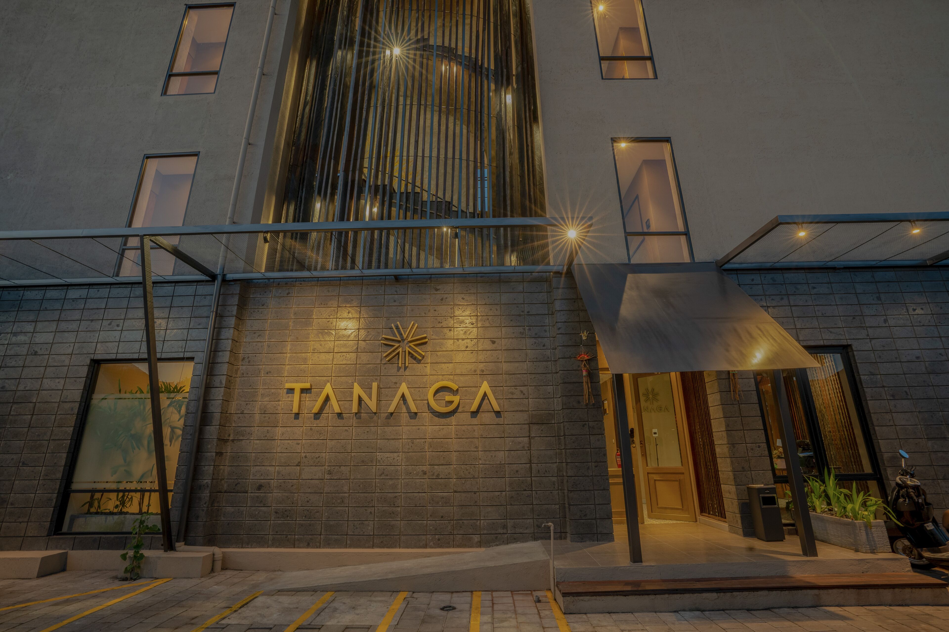 A modern building with the name "TANAGA" prominently displayed on the facade.