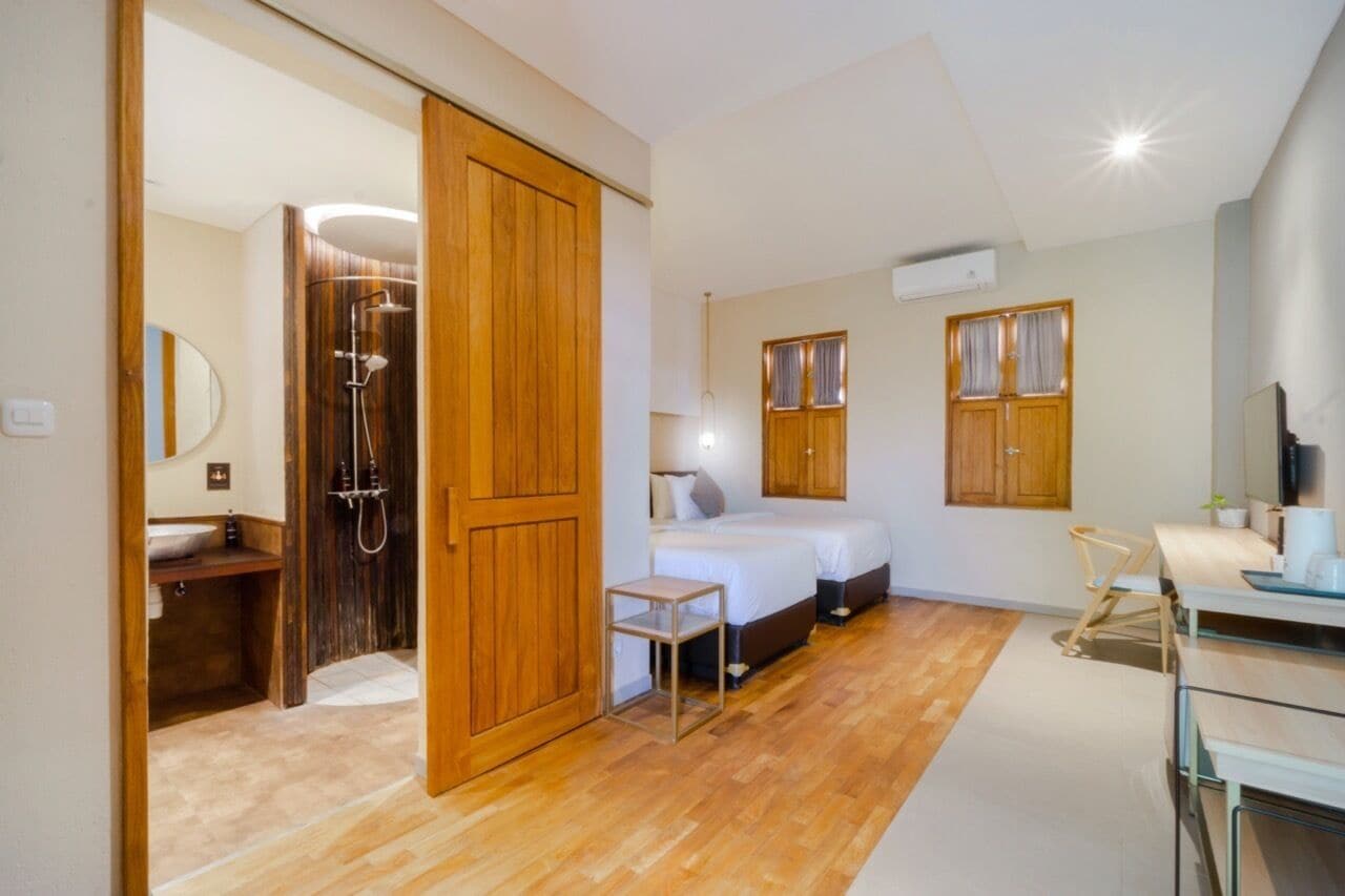 Een kleine slaapkamer met een houten garderobe, een nachtkastje, een bed en een douchehoek.
