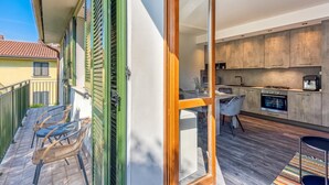 A modern kitchen with a built-in oven and a dining area with a table and chairs. - Porto Letizia Paganini 4, Porlezza, Italy (Porlezza)