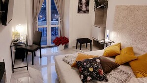Une chambre moderne avec un grand lit, un bureau et un téléviseur fixé au mur.