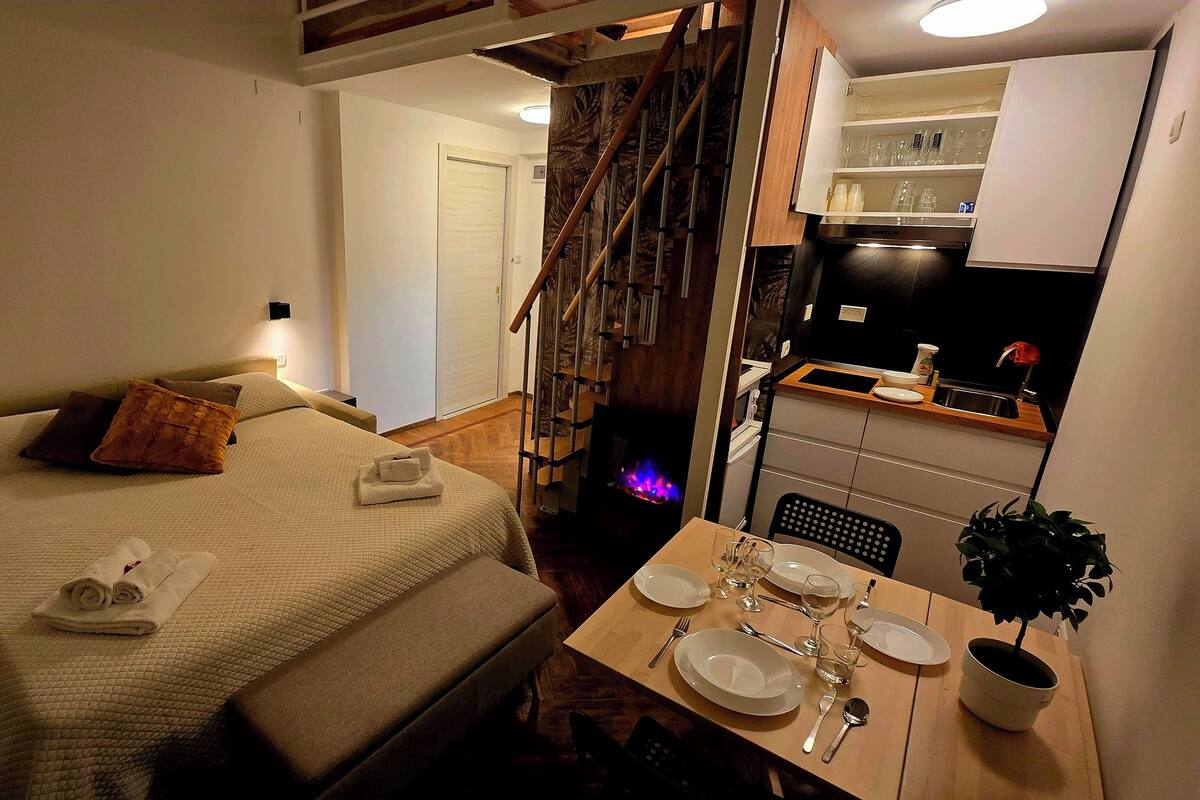 Une chambre d’hôtel avec un lit, une table de chevet et une petite kitchenette.