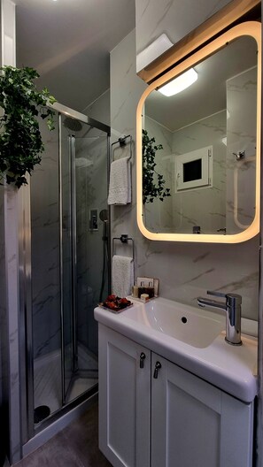 Superior driepersoonskamer | Badkamer | Een douche, een regendouche, gratis toiletartikelen, een haardroger
