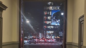 Un couloir donnant sur une rue animée la nuit.