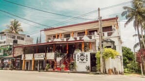 A two-story building with a balcony and a staircase leading to the upper floor. - Hummus Hotel Hikkaduwa  (Hikkaduwa)